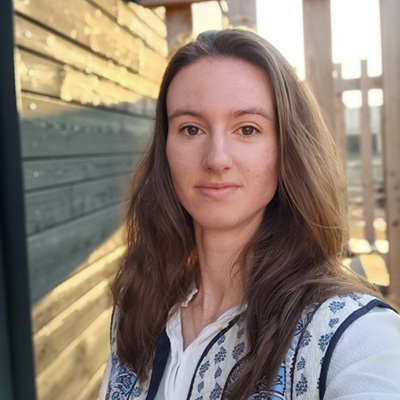 Vrouw met lang bruin haar kijkt in de camera